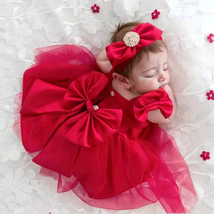 Adorable baby model wearing a red pageant dress with a large bow, showcasing popular accessories for baby. Perfect for baby accessories lovers.