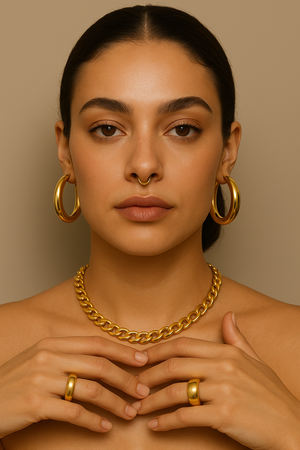 A close-up portrait showcasing a model wearing elegant gold jewelry, including hoop earrings, a chunky chain necklace, and rings. This image captures trends in jewelry and accessories, perfect for anyone exploring stylish jewelry and accessories.