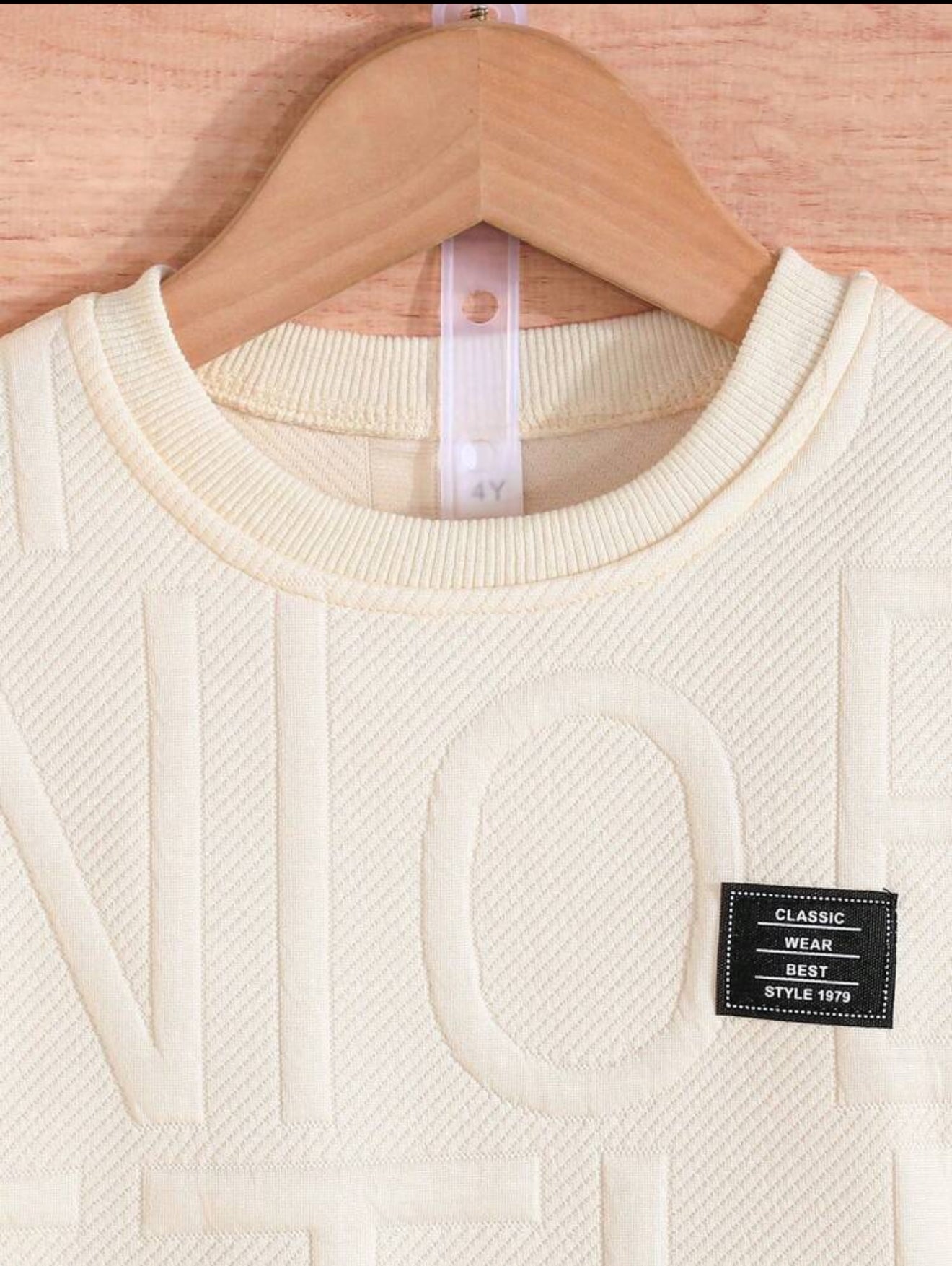 Détail du col d'un haut en blanc de la marque AURORE LUXURE. Design élégant pour l'ensemble d'été pour enfants de 4 à 7 ans. Ensemble de vêtements d'été pour jeunes garçons.