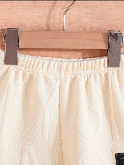 Détail de la taille d'un short blanc de la marque AURORE LUXURE. Conçu pour être confortable pour les enfants de 4 à 7 ans. Ensemble d'été pour jeunes garçons.