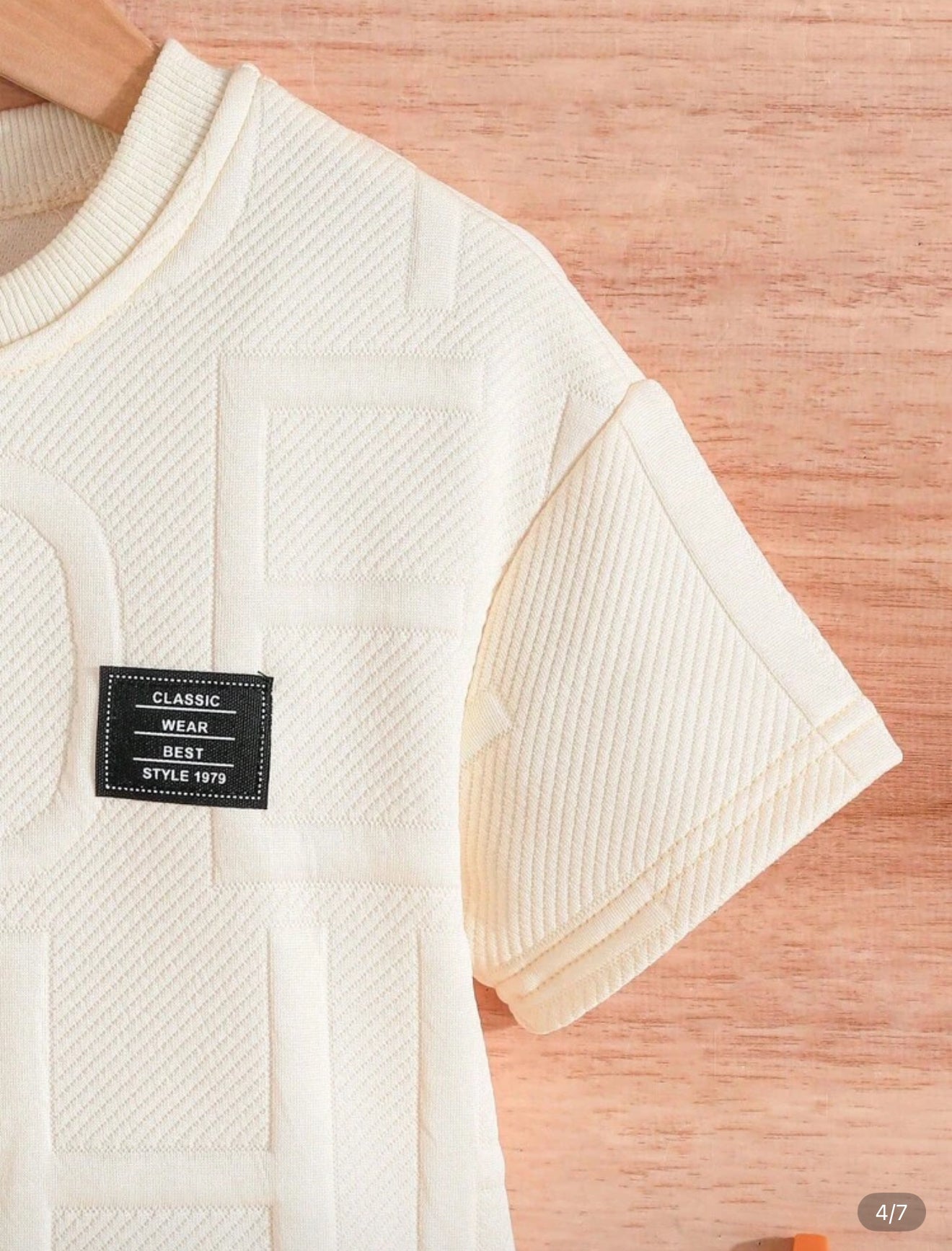 Détail de la manche d'un haut blanc de la marque AURORE LUXURE. Élégant et confortable pour un été décontracté pour enfants de 4 à 7 ans.